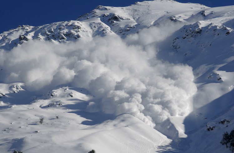 A cloud of powdery snow rises from a massive avalanche in the Caucasus.