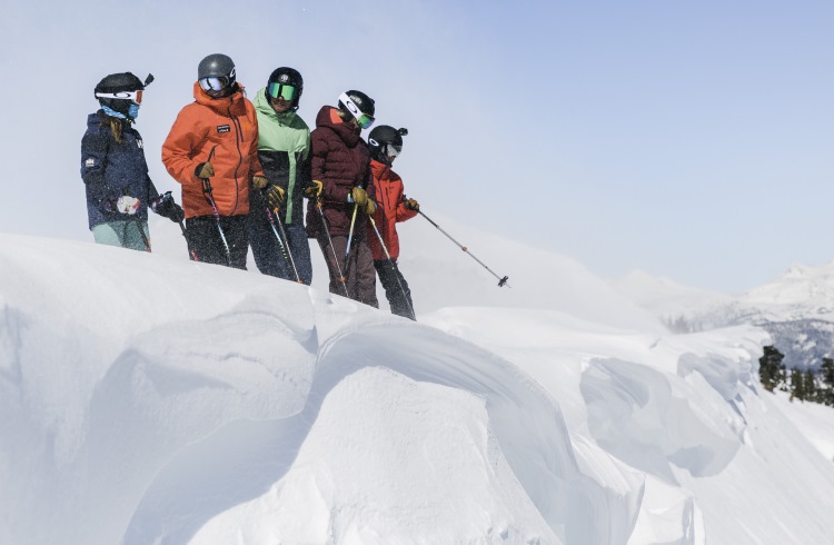 An instructor and students stand on a snowy crest during an avalanche safety class in Kirkwood, California.