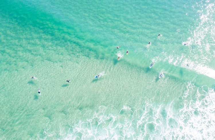An aerial shot of surfers in the ocean