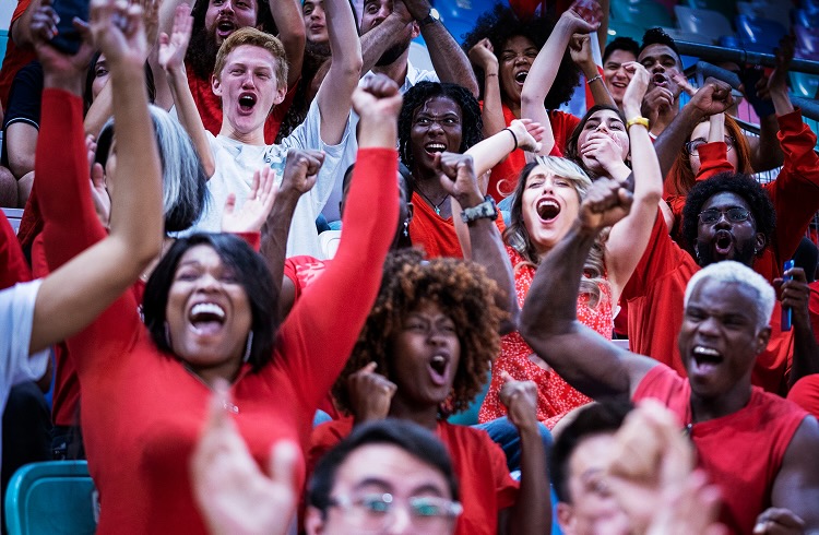 Enthusiastic audience raise their arms up to cheer in celebration of their home soccer team