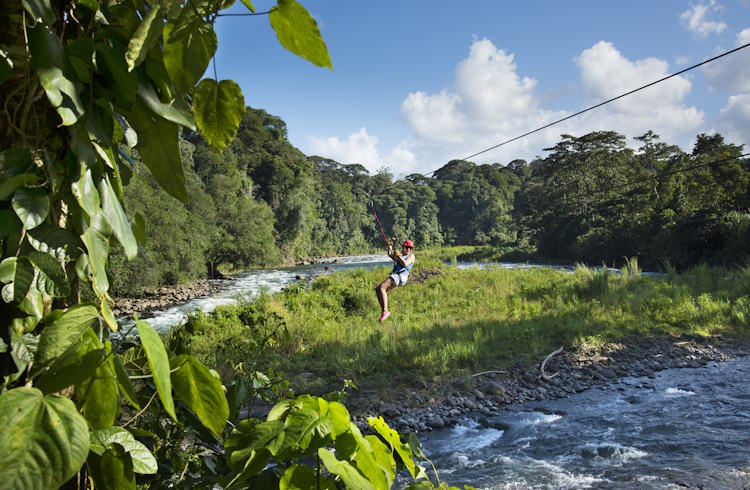 A woman ziplines across the Sarapiqui River in Costa Rica.