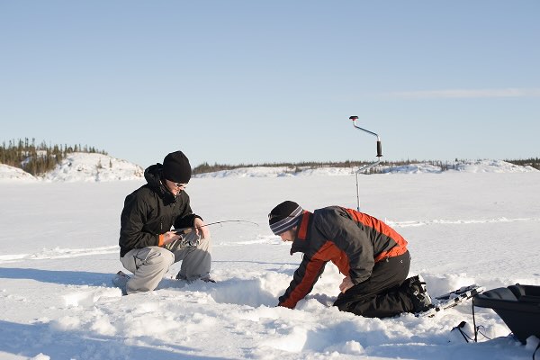two people ice fishing in the snow