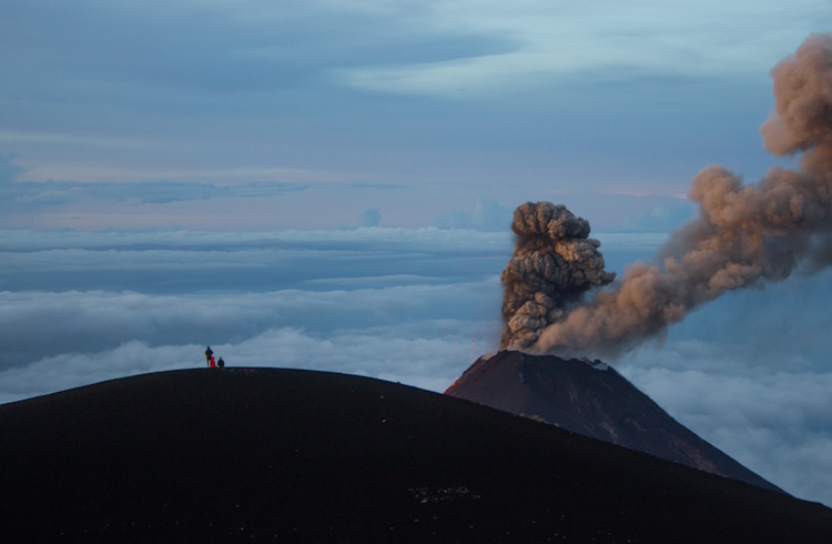 Hikers at the top of Guatemala's Acatenango Volcano watch neighboring Volcano Fuego spew ash.