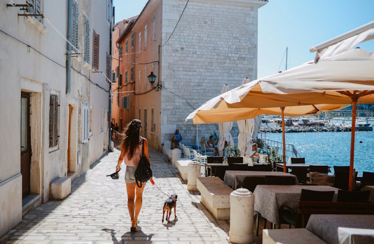 A woman walks her dog along the streets of Rovinj, Croatia.