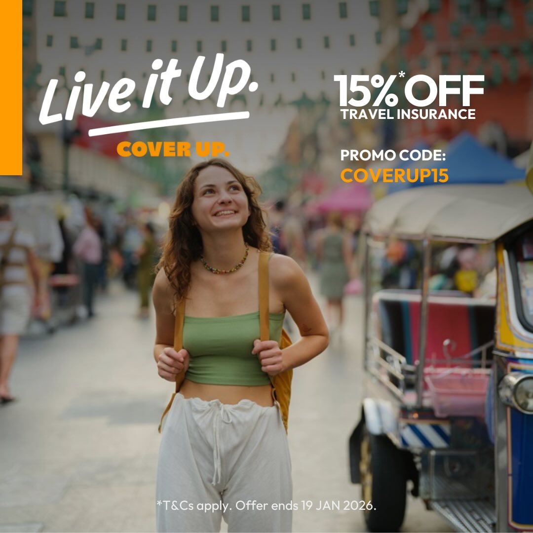 A smiling woman walking down a road with a backpack